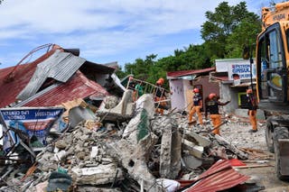 Rescuers search for three people who were reported missing under the rubble of a collapsed building in Bogo City